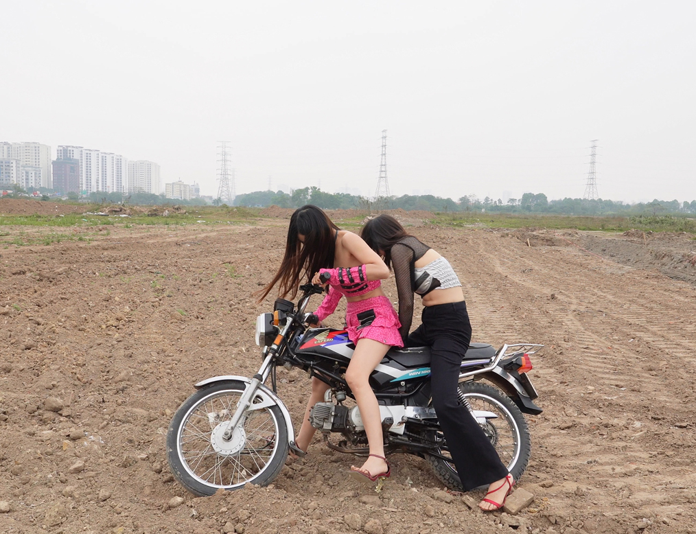 Two Girls Learn To Ride An Old Honda Motorcycle On A Rough Dirt Field